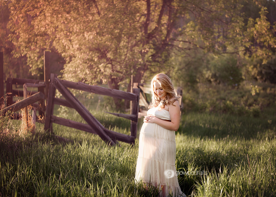 maternity outdoor pose in long dress by fence