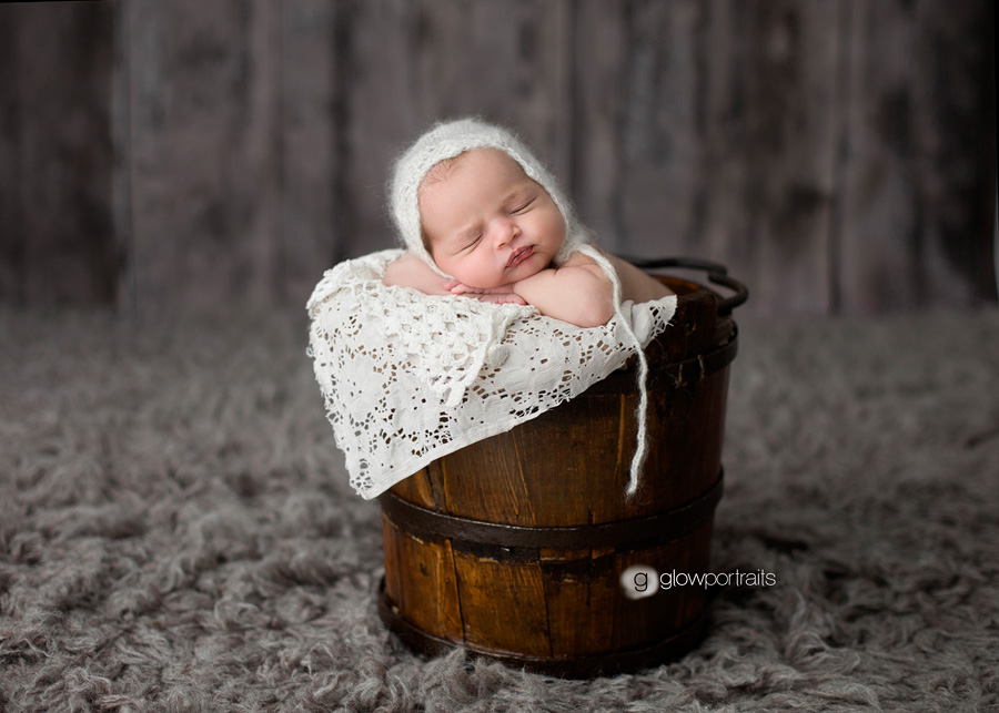 baby in bucket with bonnet