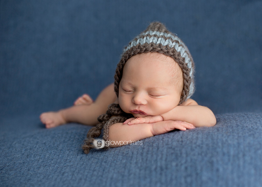 baby lying on arms with hat on