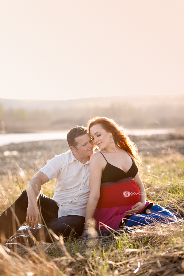 wife and husband snuggling outdoor maternity