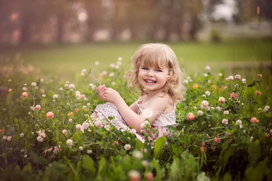 little girl sitting in flower field