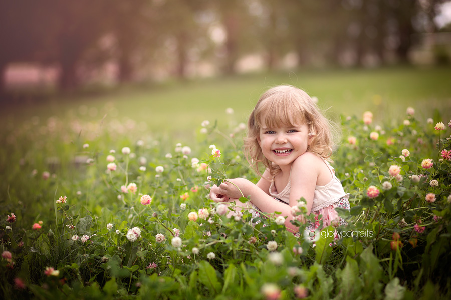 girl sitting in flower field smiling
