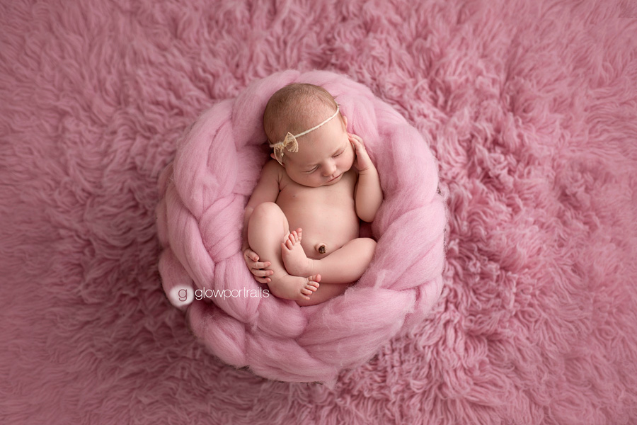 british columbia newborn photographer newborn girl curled up on pink rug