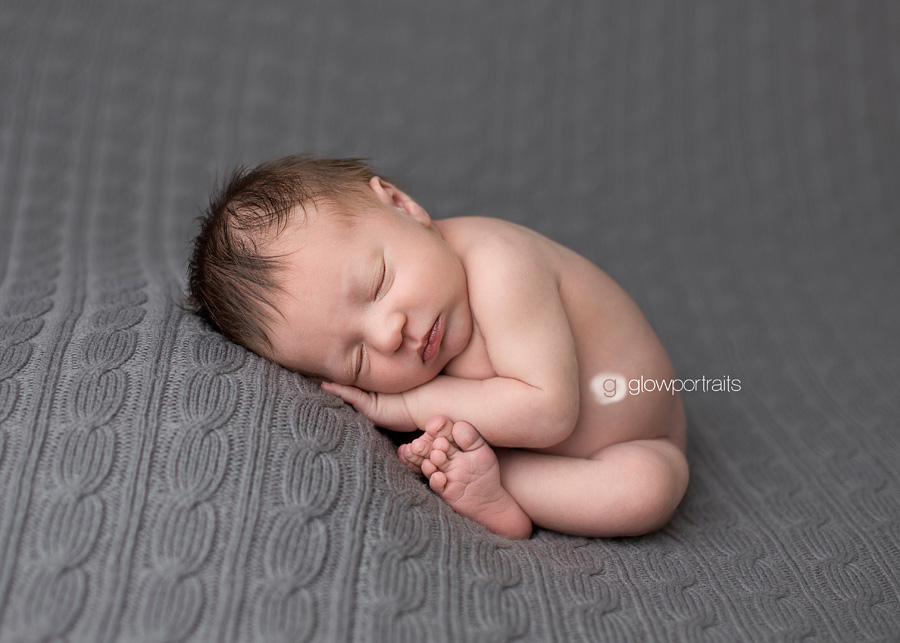 taco newborn pose on gray blanket