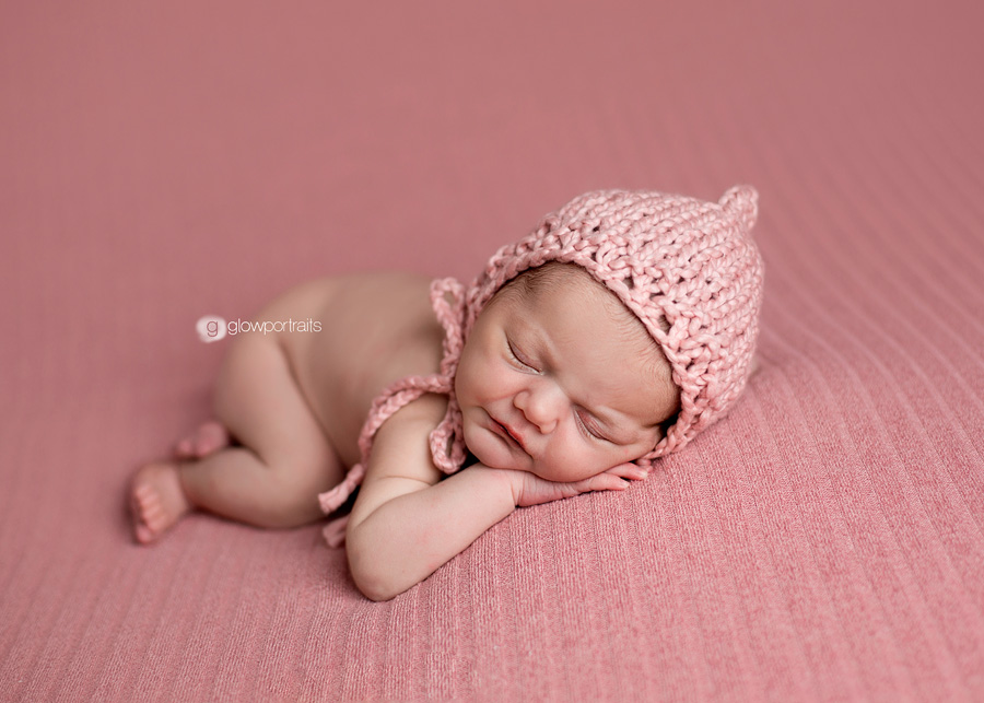 sweet newborn baby girl in pink fabric