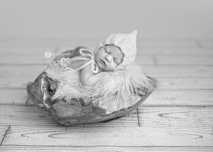baby with had on in wood bowl