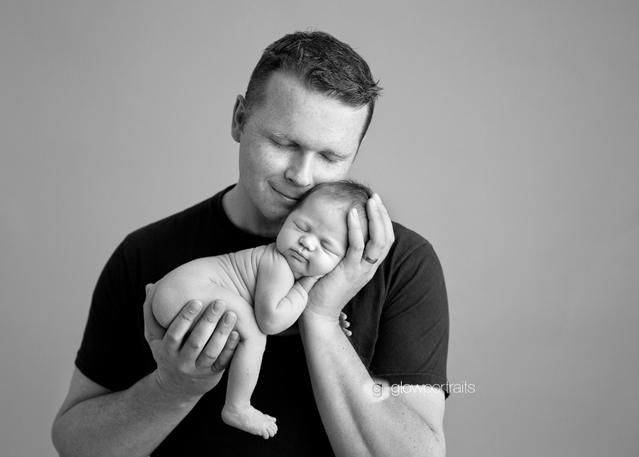 dad snuggling newborn