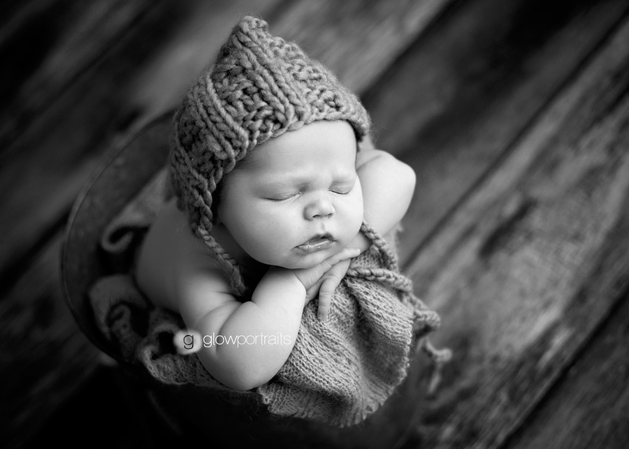 newborn baby wearing hat in bucket