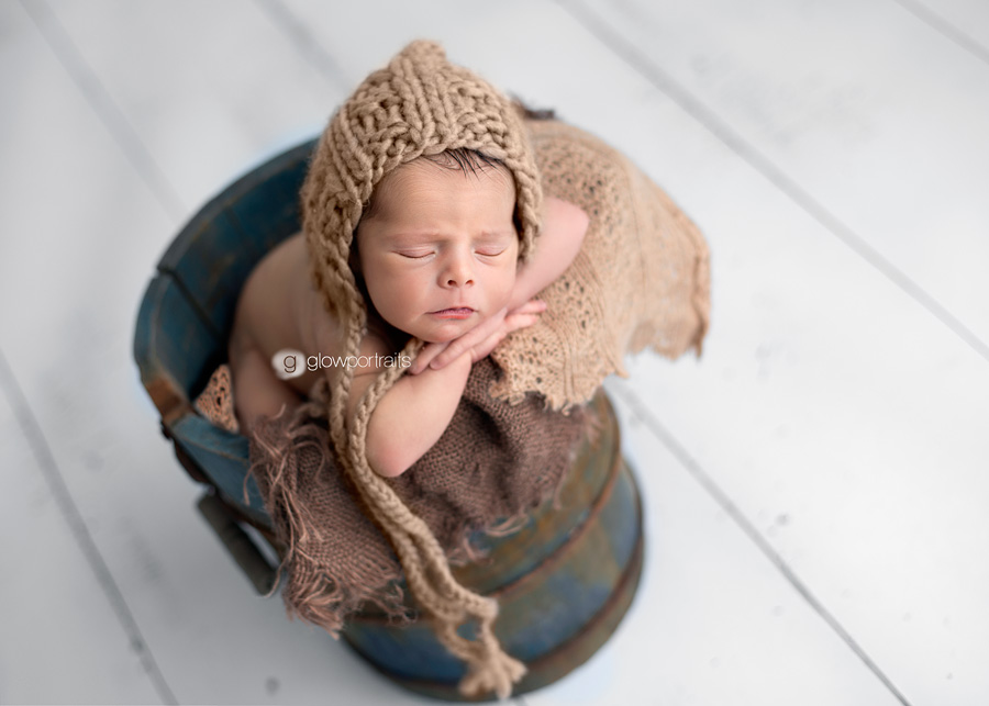 baby with hat on in bucket