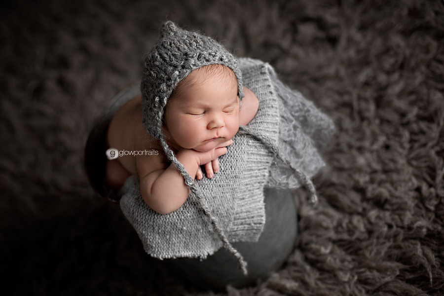 baby boy in bucket and gray bonnet on