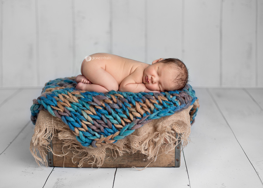 newborn on tummy on box