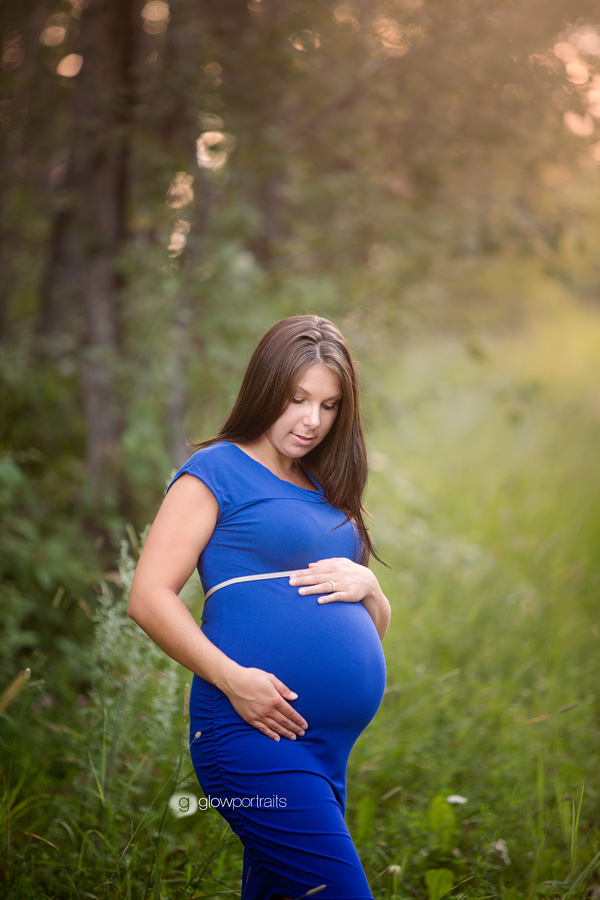 pregnant girl wearing blue dress outside posing