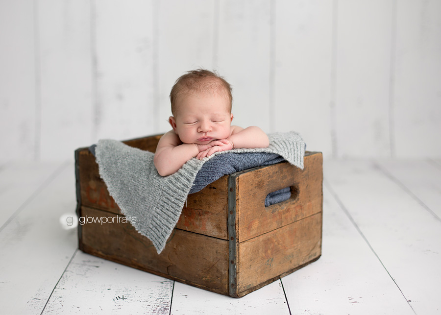 newborn boy in box with layers