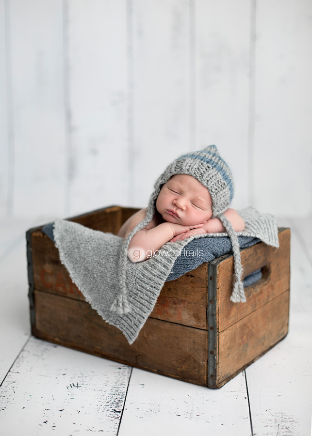baby in wooden box with hat on