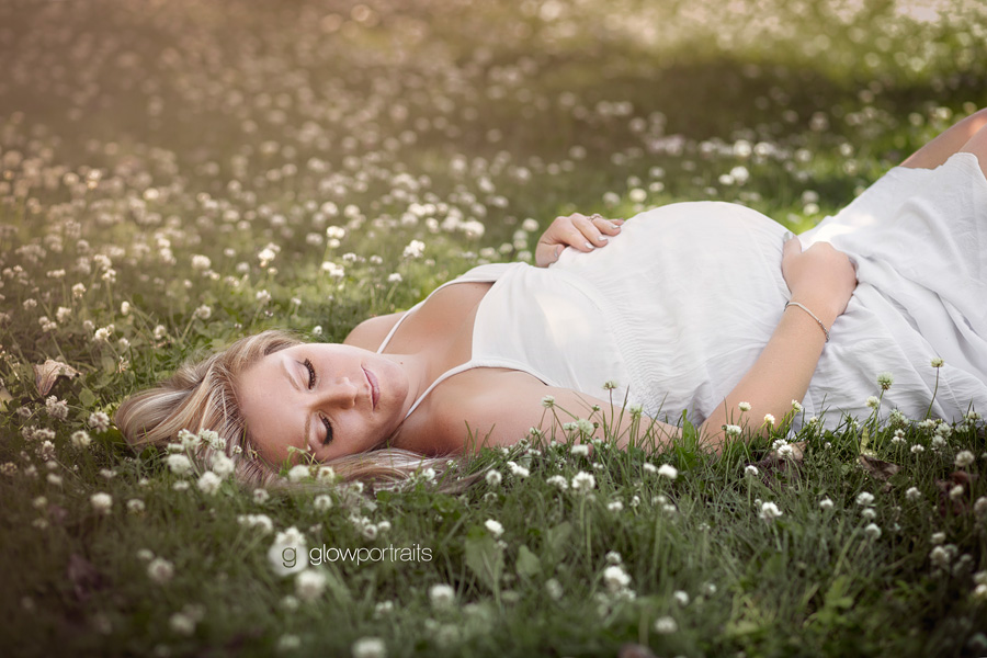 peace river area maternity photographer outside lying down in white dress maternity session