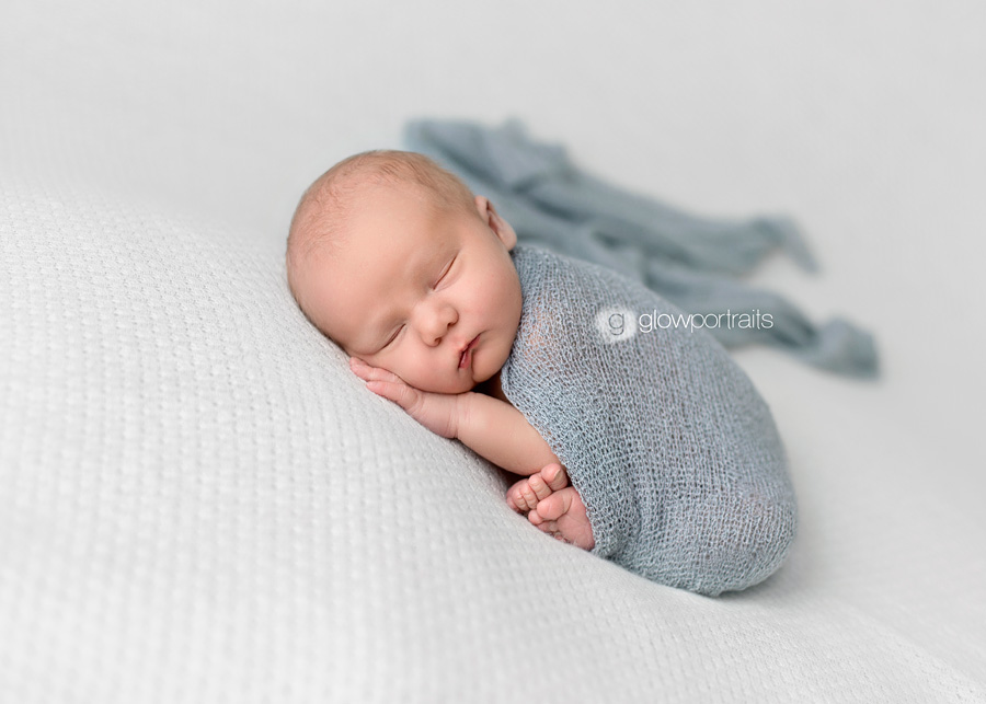 newborn boy wrapped in blue blanket
