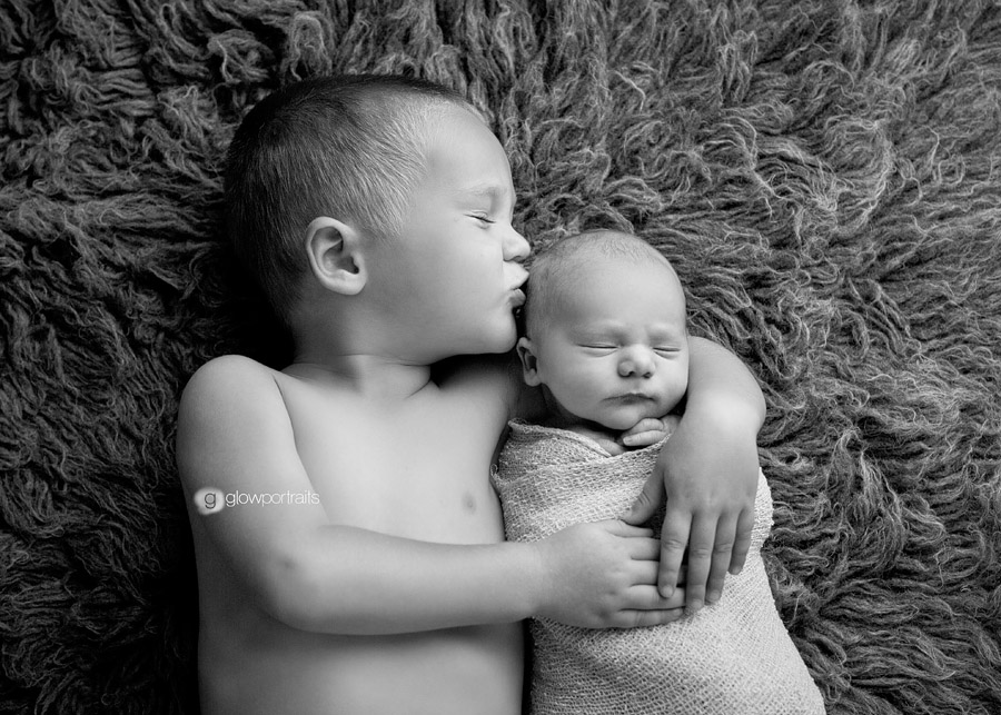 brother kissing his baby 