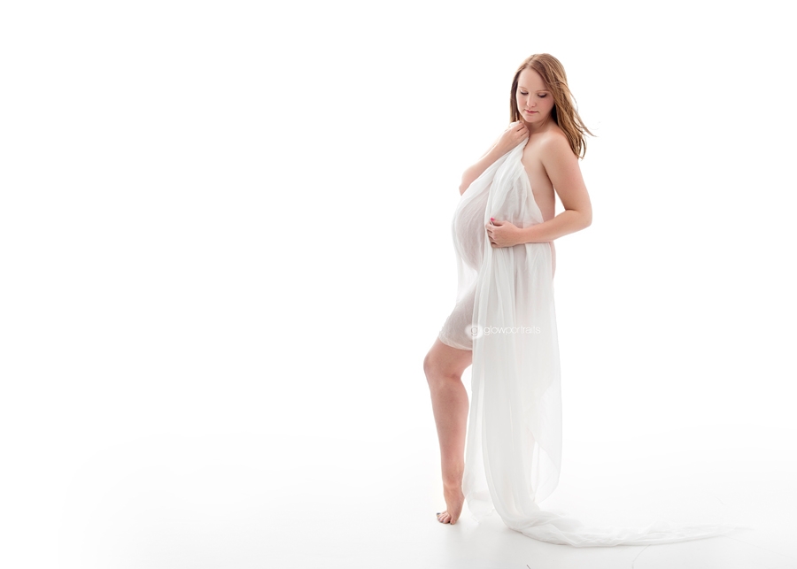 glow portraits maternity photographer white background maternity pose holding white gauze