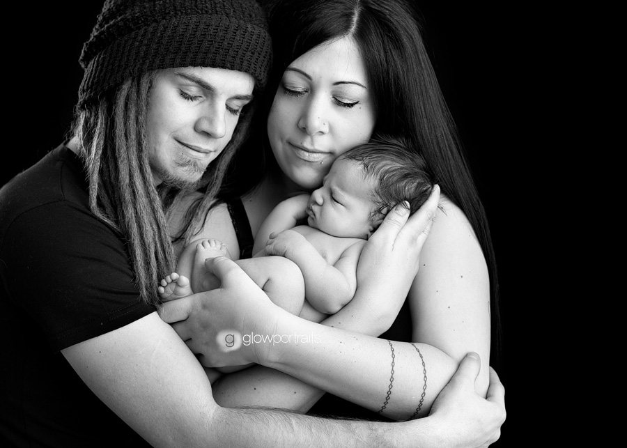 mom and dad snuggle their new baby boy