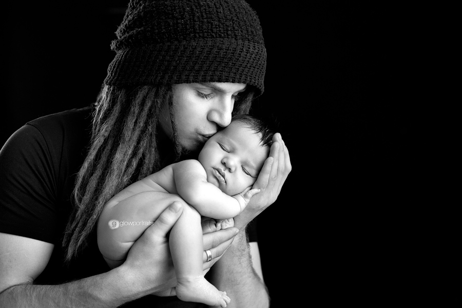 dad holding newborn and kissing him