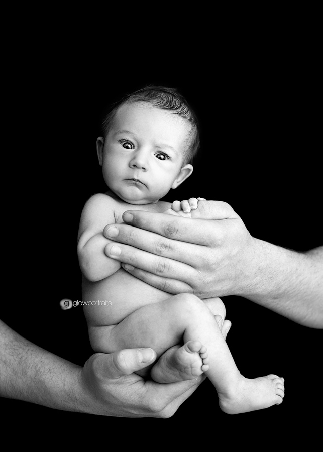 awake newborn in dad's hands