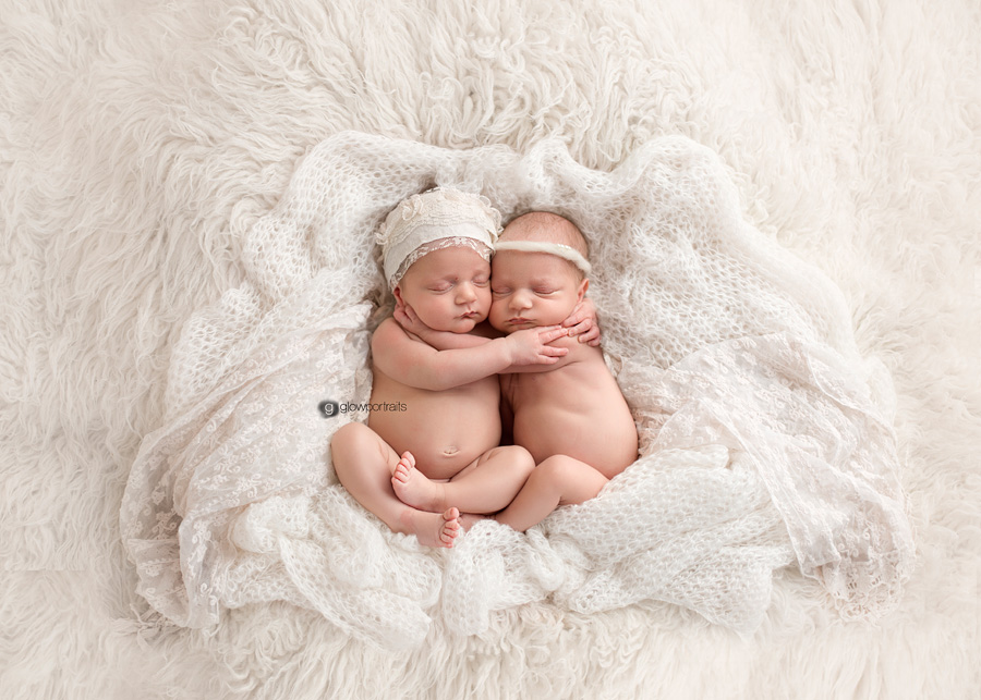 twin girls snuggling on cream fur