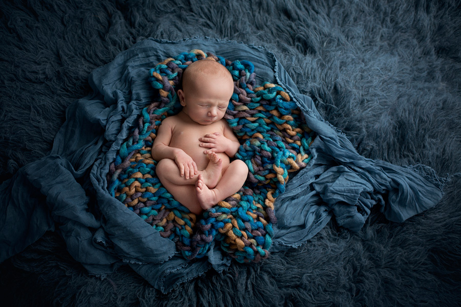 newborn boy on blue flokati fur