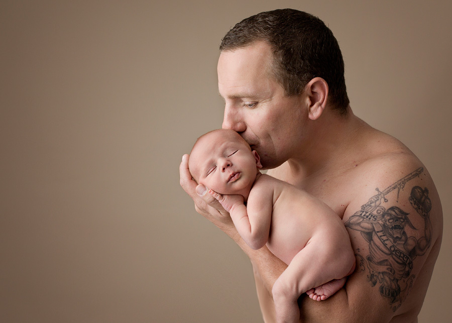 dad snuggling newborn baby