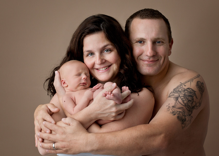 parents holding newborn pose