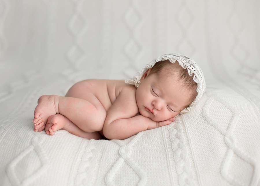 snuggle newborn pose on white blanket