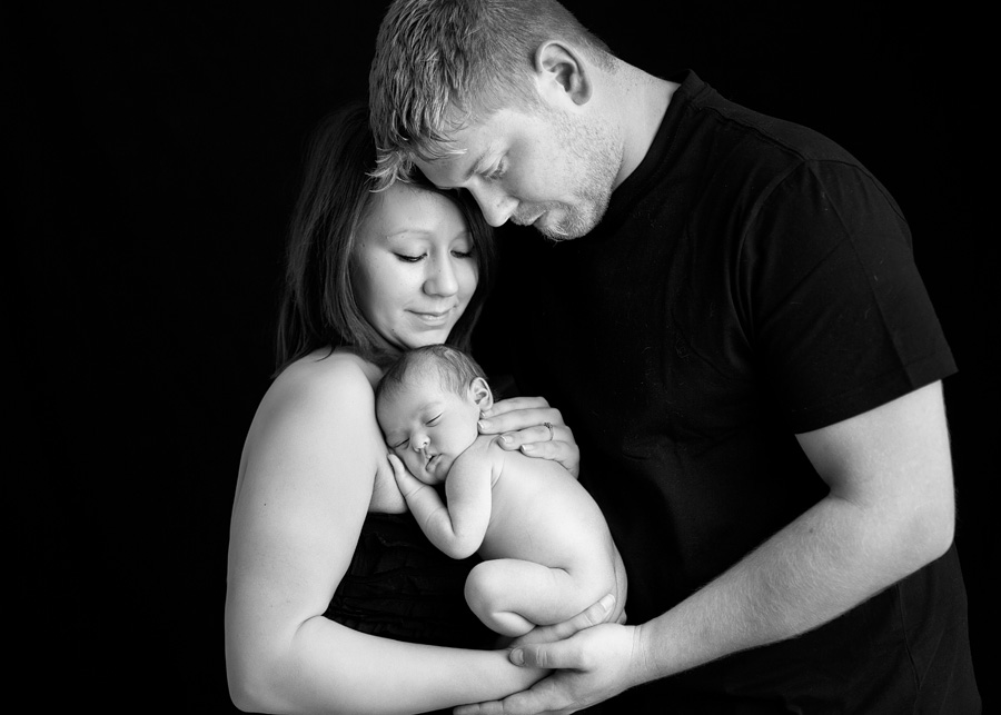 mom, dad and newborn pose