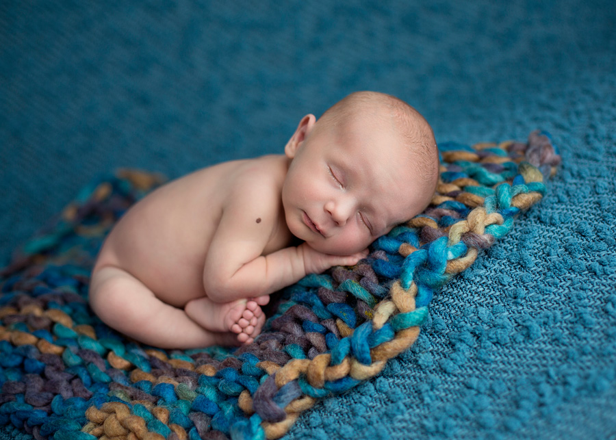 taco newborn pose on blue fabric