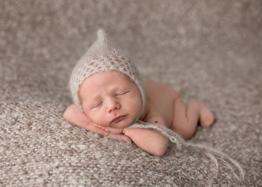 newborn boy wearing beige hat