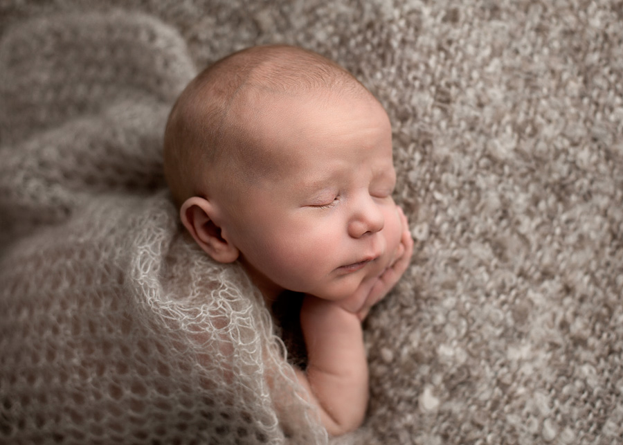 close up of newborn on beige fabric