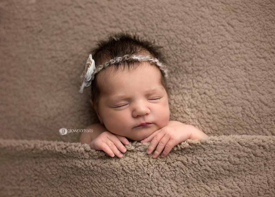 newborn girl snuggled on blanket