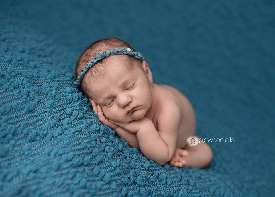 newborn girl on blue fabric
