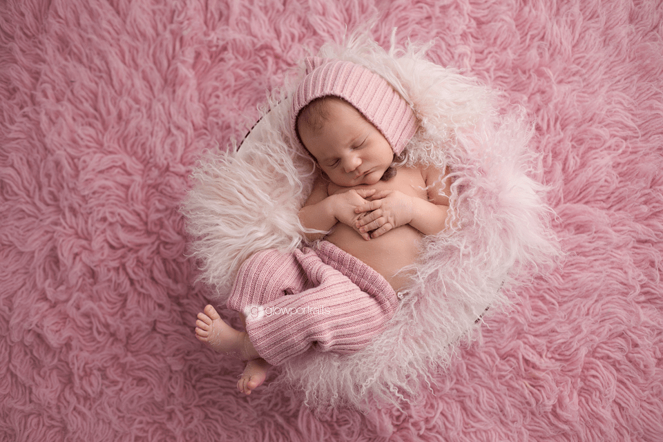 baby girl on pink fur wearing pants