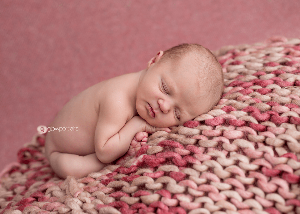 baby on pink fabric in taco pose
