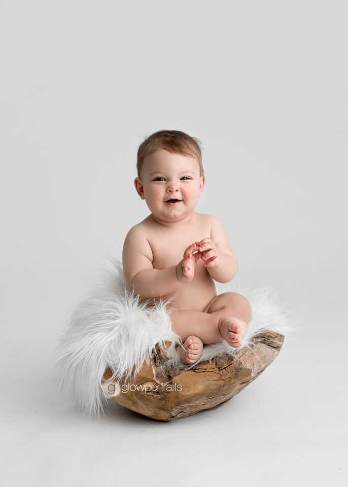 little baby boy sitting in bowl with white fur