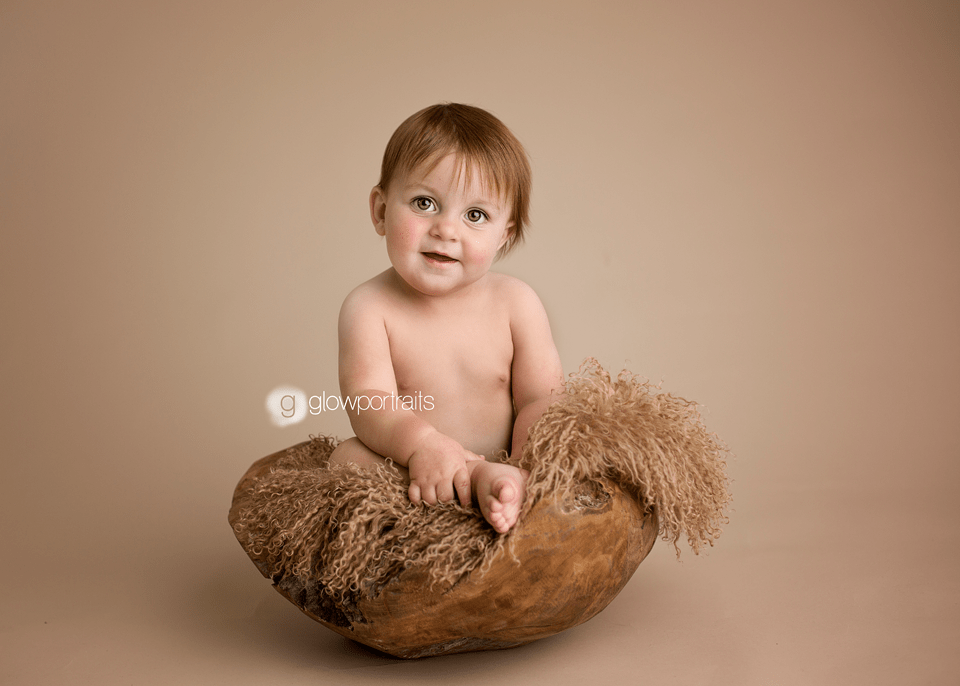 cute little boy baby sitting in wooden bowl